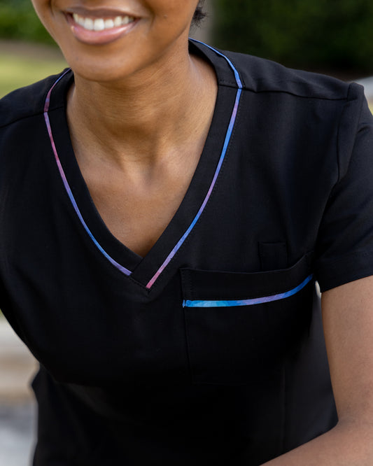 ENDYS Aurora women's scrub top front view — signature Aurora watercolor print on pockets and neckline
