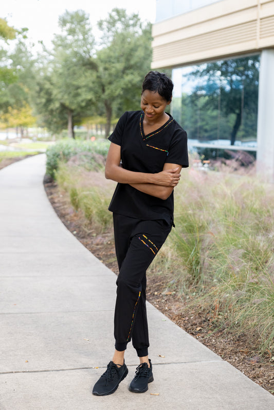 ENDYS Heritage Pop women's black scrub top front view — signature Heritage Pop print on pockets and neckline